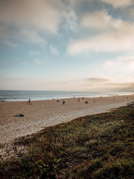 Foto vertical de uma praia de areia no Rio, Brasil, em um dia nublado