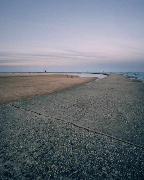 Foto vertical de uma praia vazia e um céu azul claro