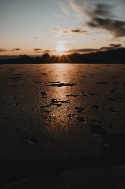 Foto vertical de uma superfície molhada refletindo a luz do sol