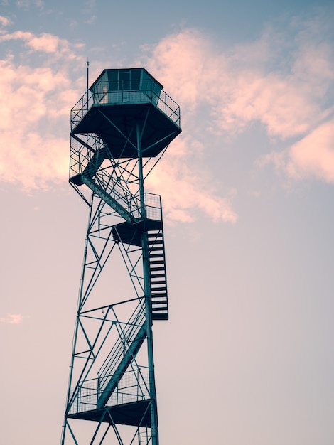 Foto vertical de uma torre de observação sob o lindo pôr do sol