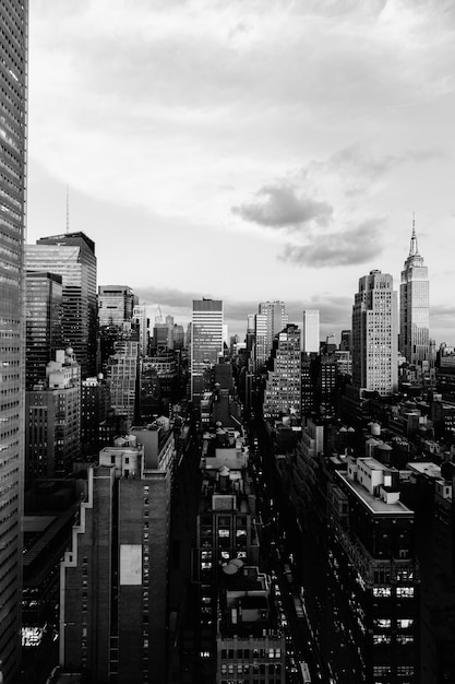 Foto vertical em escala de cinza dos edifícios e arranha-céus na cidade de Nova York, Estados Unidos