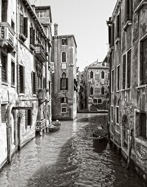 Foto grátis foto vertical em tons de cinza de um canal no distrito histórico de veneza, itália