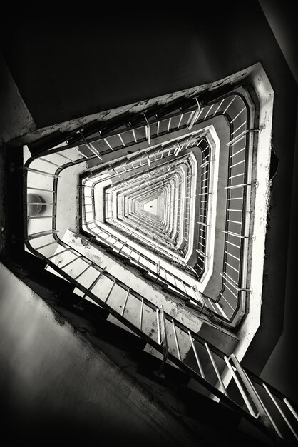 Foto vertical em tons de cinza de uma escada em um prédio