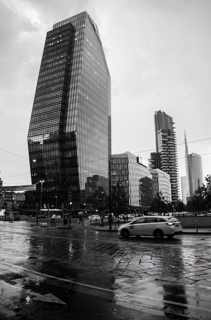 Foto vertical em tons de cinza de uma rua com edifícios modernos em Milão, Itália