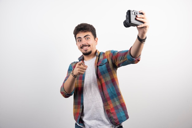 Fotografe tirando selfies de maneira positiva com uma câmera.
