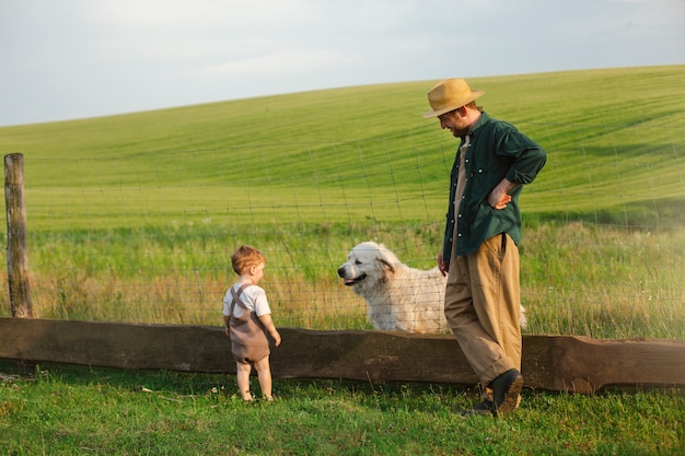 Foto grátis fotografia completa de pai e filho a viver no campo.