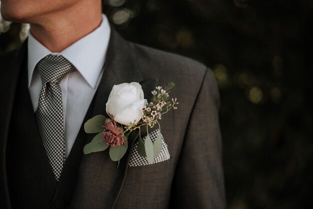 Fotografia em close-up de um homem vestindo um smoking com um boutonniere no bolso