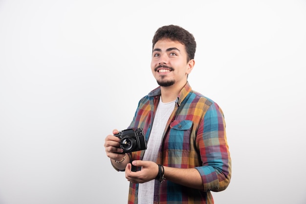 Fotografia jovem experiente em tirar fotos profissionais de maneira séria.