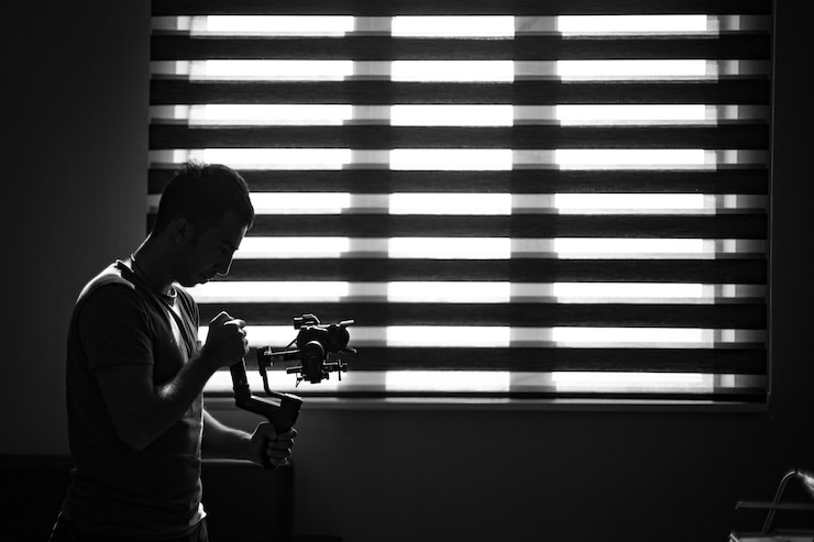 Foto grátis fotógrafo checando sua câmera na escuridão