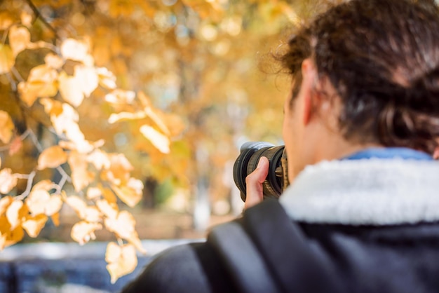 Fotógrafo da natureza fotografando folhas em cores de outono no parque