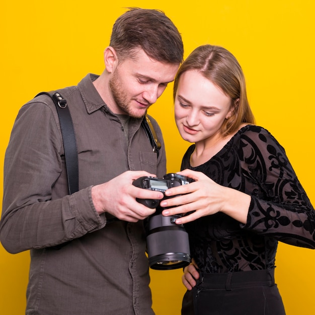 Fotógrafo e modelo verificando fotos na câmera