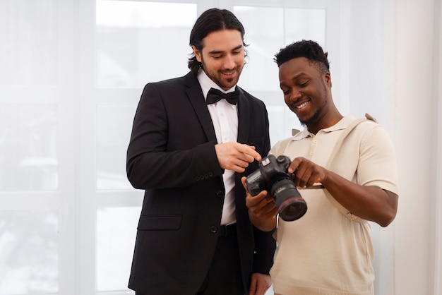 Foto grátis fotógrafo e noivo de plano médio