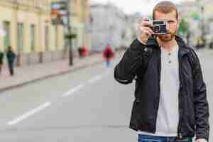 Foto grátis fotógrafo em pé na rua