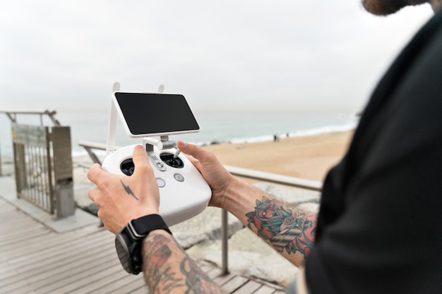 Fotógrafo ou cinegrafista amador ou profissional monta um set para filmar da paisagem aérea do oceano com drone ou quadrocopter.