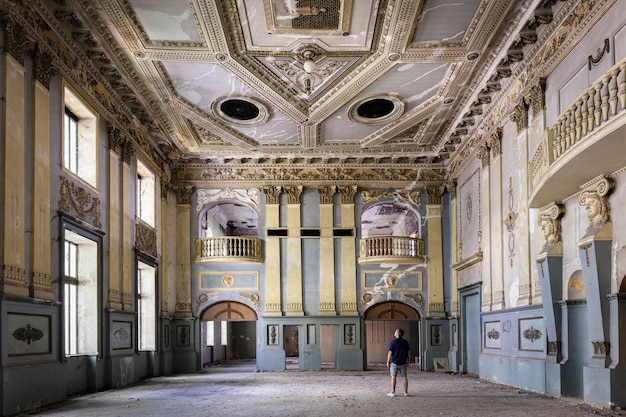 Fotógrafo parado em um salão de clube abandonado em Tbilisi, Geórgia