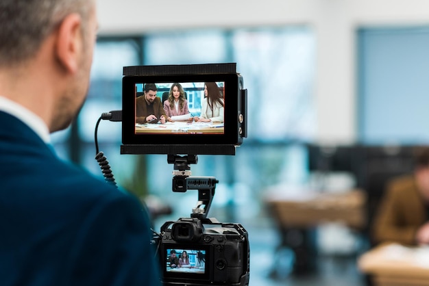 Fotógrafo profissional filmando uma reunião de negócios em um escritório