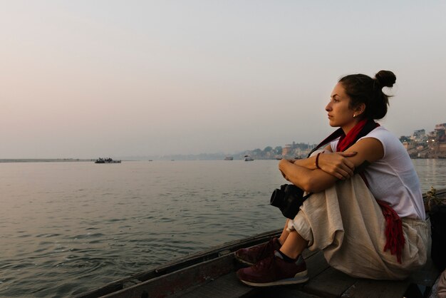Fotógrafo sentado em um barco no rio Ganges