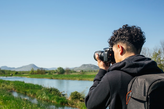 Fotógrafo viajante tirando foto com mochila de transporte