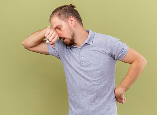 Fraco, jovem, bonito, eslavo, homem, segurando, mão, cintura, segurando, guardanapo, colocando a mão, nariz, com, olhos fechados, isolado, ligado, verde oliva, parede