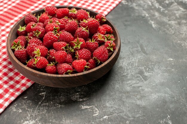 Framboesas vermelhas frescas de vista frontal dentro do prato na foto a cores cinza fruta baga cranberry selvagem