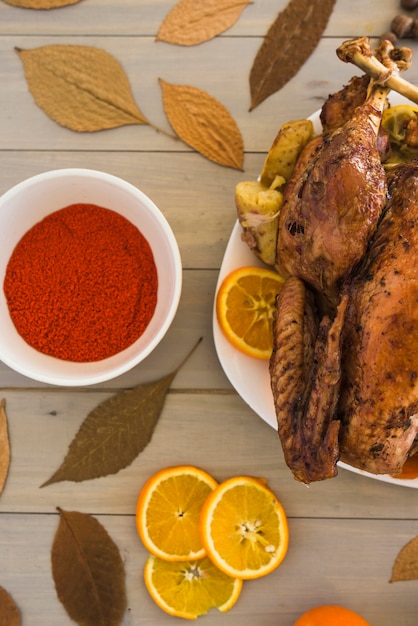 Frango assado com laranjas na mesa