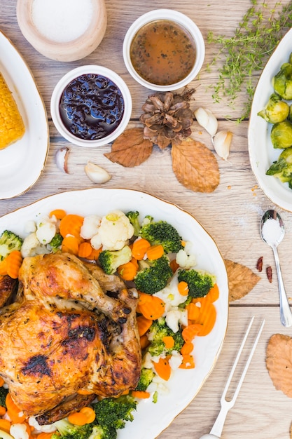 Frango assado com tigelas de molho na mesa