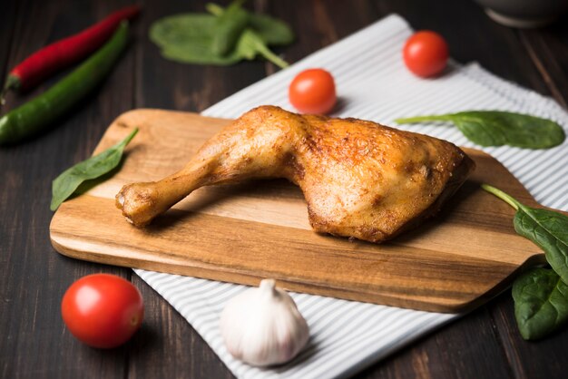 Frango close-up na placa de madeira com ingredientes