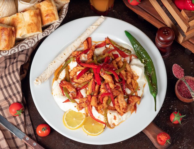 Frango fajita, filé de frango frito com pimentão em panela com fatias de pão em chapa branca