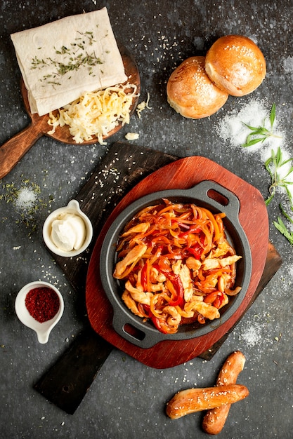 Frango frito com pimenta e cebola em uma panela de alumínio