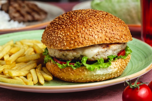 Frango hambúrguer alface tomate queijo batatas fritas vista lateral