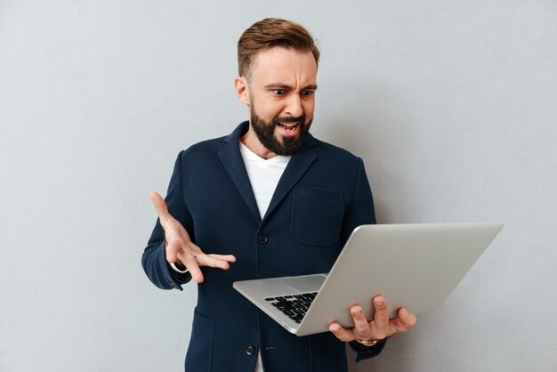 Franzir a testa homem sério no terno usando laptop isolado