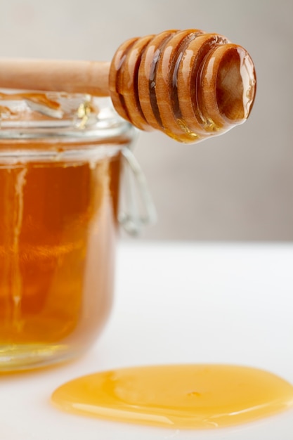Frasco de mel com concha de mel de madeira