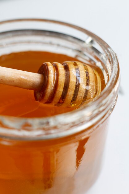 Frasco de mel com concha de mel de madeira