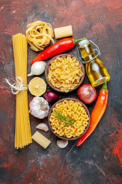 Foto grátis frasco de óleo de massas não cozidas e alimentos para a preparação do jantar na mesa de cores misturadas