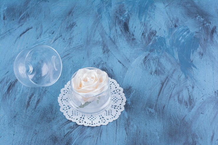 Foto grátis frasco de vidro de uma única rosa branca em azul.