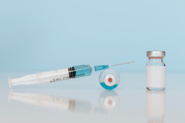 Foto grátis frascos de seringa e vacina na mesa