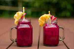 Foto grátis frascos de vidro ao ar livre com suco de fruta do dragão