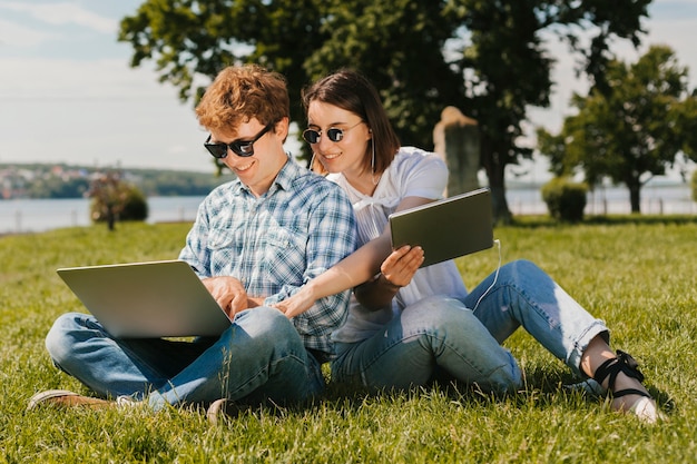 Foto grátis freelancers felizes trabalhando no parque