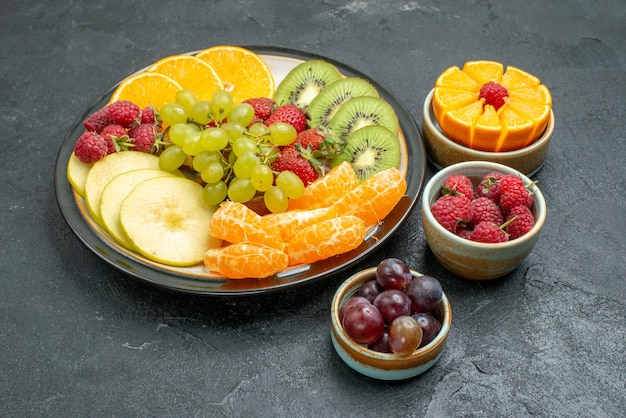 Frente, composição de frutas diferentes frutas frescas e frutas fatiadas em fundo escuro saúde frutas maduras frescas