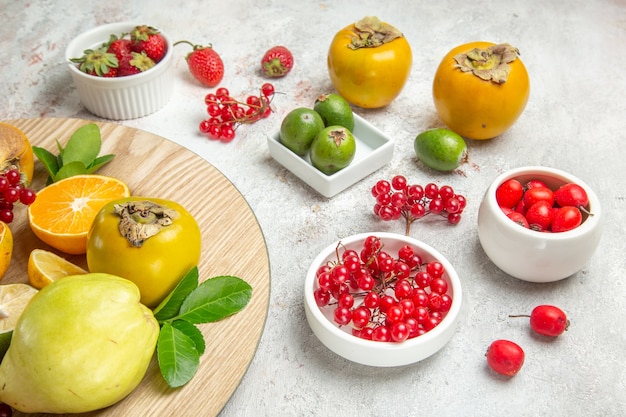 Frente composição de frutas diferentes frutas na mesa branca cor de frutas baga frescas maduras