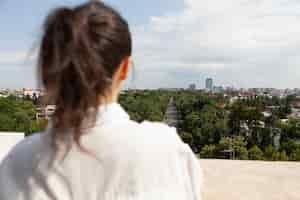 Foto grátis frente de trás de uma mulher olhando a vista panorâmica da cidade metropolitana