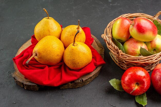 Frente, frutas frescas, pêras e maçãs na mesa escura, maduras de cor fresca