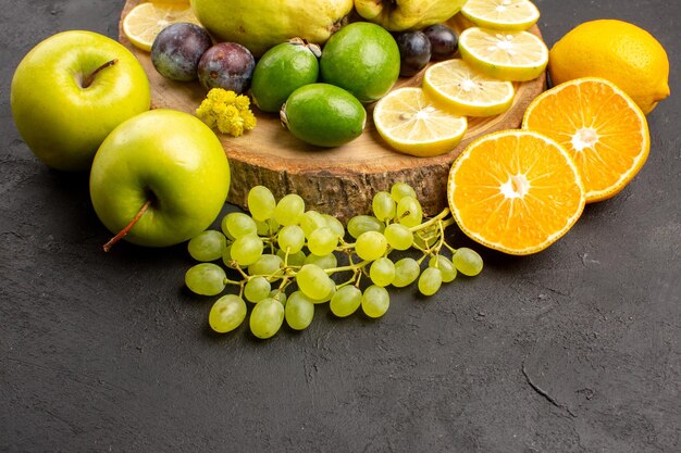 Frente frutas frescas uvas fatias de limão ameixas e marmelos em fundo escuro frutas frescas maduras planta árvore