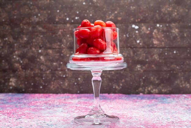 Frente frutas vermelhas frescas dentro de um vidro transparente na mesa roxa frutas frutas frescas maduras azedas