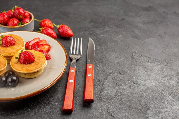 Frente panquecas gostosas com frutas na superfície escura torta de bolo de frutas