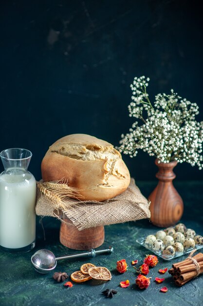 Frente pão fresco saboroso com nozes e leite na superfície escura