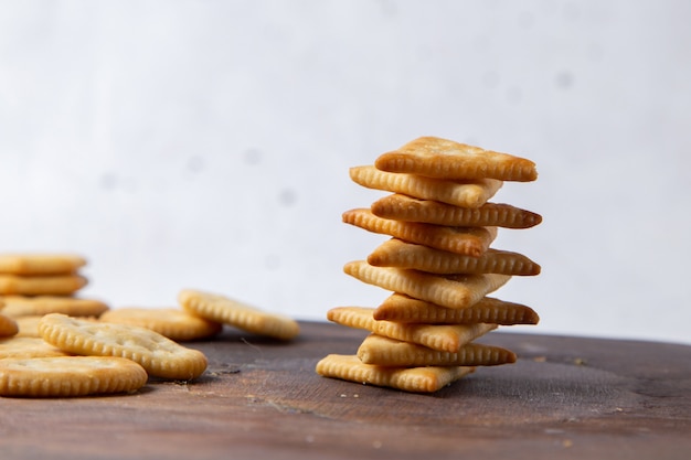 Frente salgados saborosos batatas fritas forradas em uma mesa de madeira e biscoitos crocantes leves