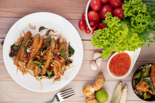 Fried Chicken Feet com ervas em um prato branco e molho.