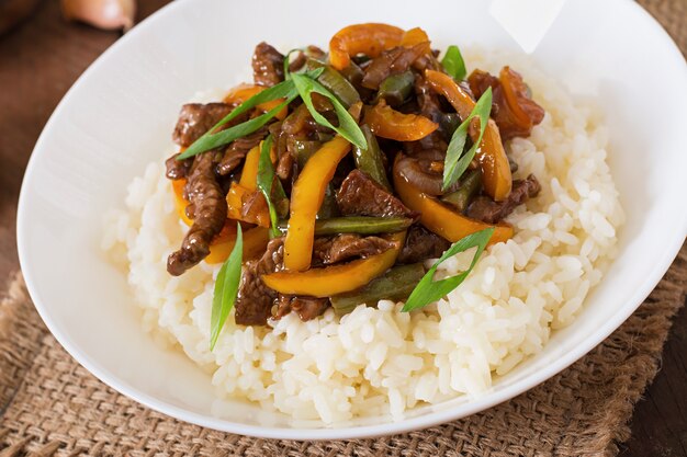 Frite a carne com pimentão, feijão verde e arroz