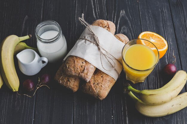 Frutas e bebidas perto de pãezinhos